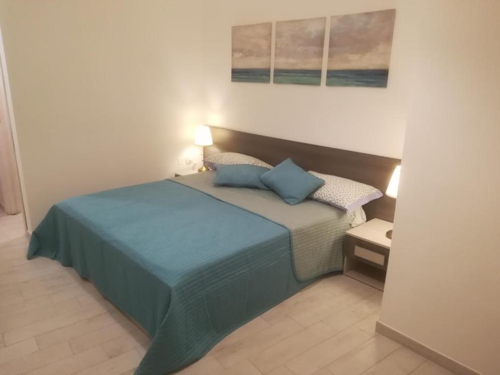 a bedroom with a bed with blue pillows on it at Al Centro di Avellino, Casa vacanze Positano in Avellino