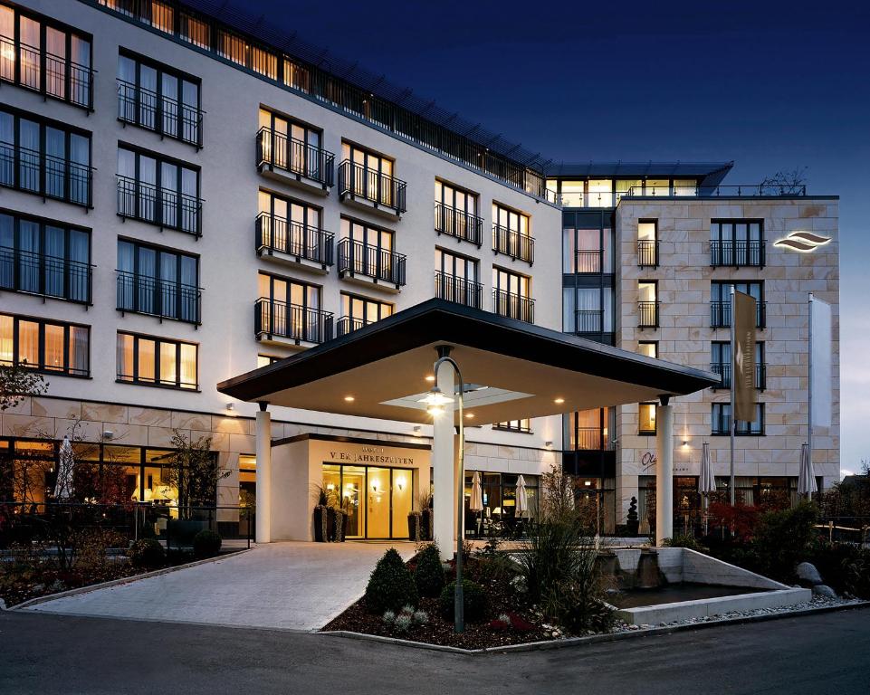 ein großes weißes Gebäude mit einem Innenhof davor in der Unterkunft Hotel Vier Jahreszeiten Starnberg in Starnberg