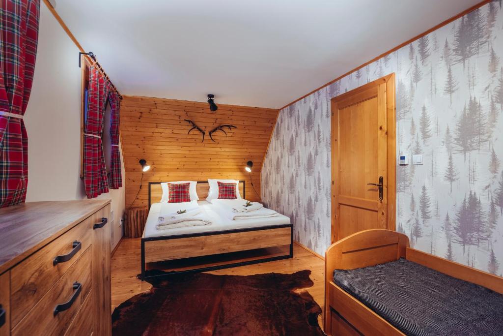 ein kleines Schlafzimmer mit einem Bett und einer Holzwand in der Unterkunft Liptovské Chaty in Liptovský Mikuláš