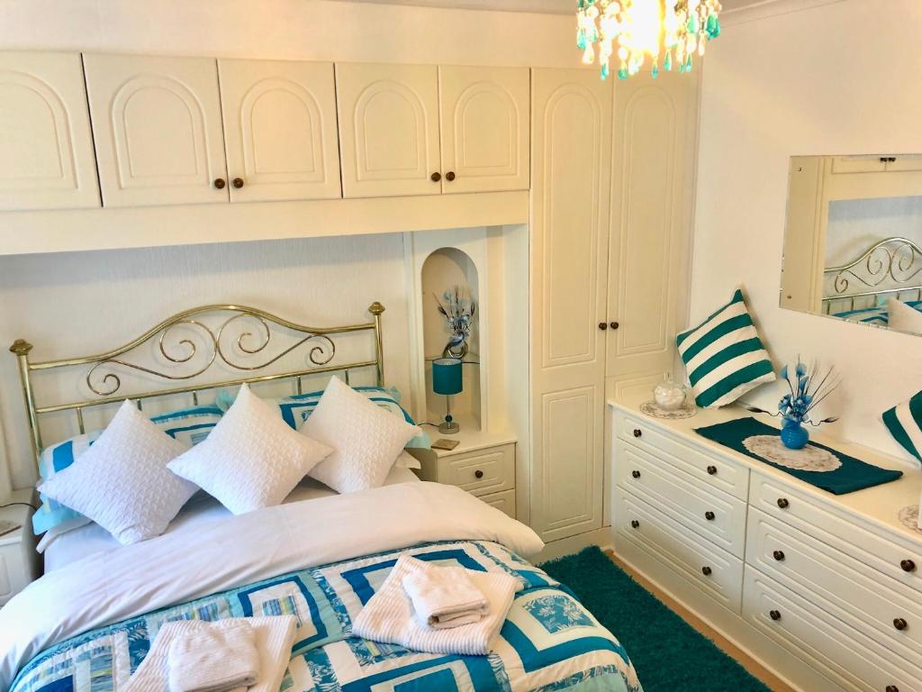 a bedroom with a bed with a dresser and a mirror at Villa Marina in Scarborough