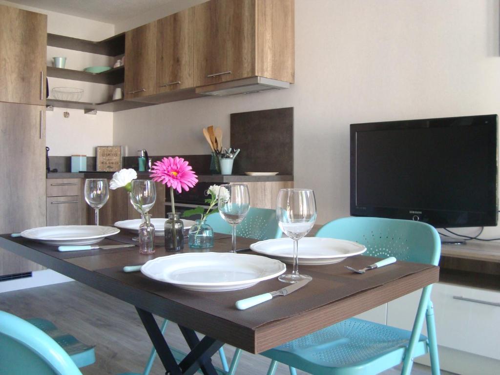 uma mesa de jantar com pratos e copos de vinho em Au cœur de Port Fréjus - T2 30 m² - Tout à pied em Fréjus