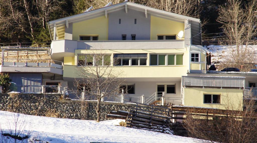 una casa en una colina en la nieve en Apart Garni Dorfblick, en Kappl