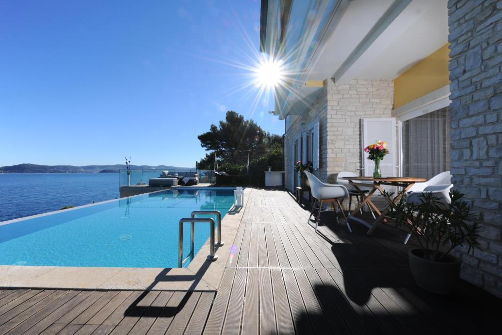 a swimming pool with chairs and a table on a deck at Villa Cablex in Crveni Vrh