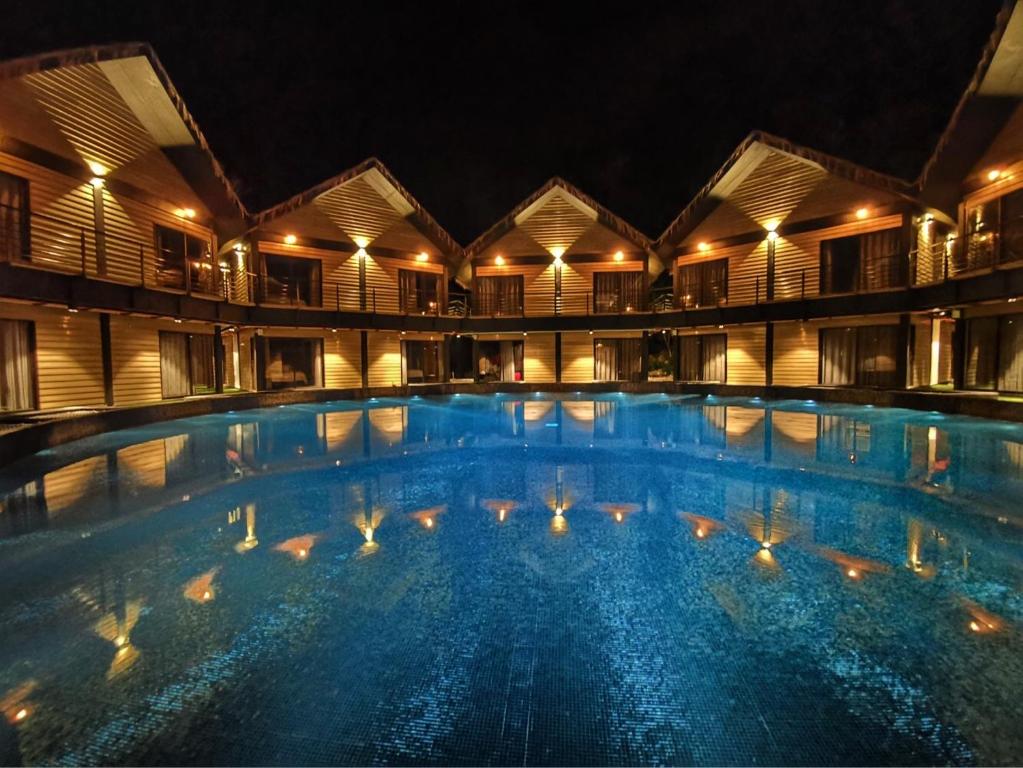 uma grande piscina à noite com luzes em A Rock Resort Langkawi - Coral Reefs em Kuah
