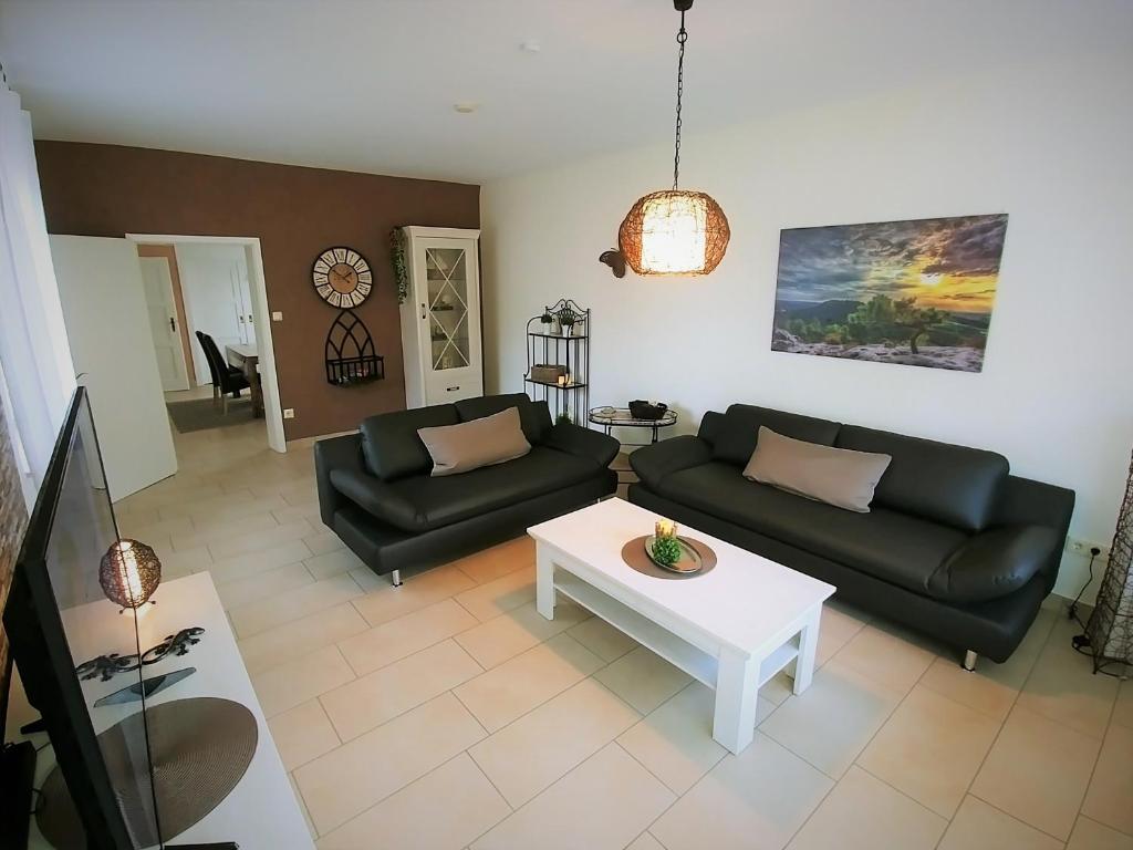 a living room with two black couches and a table at Haus Spengler in Celle