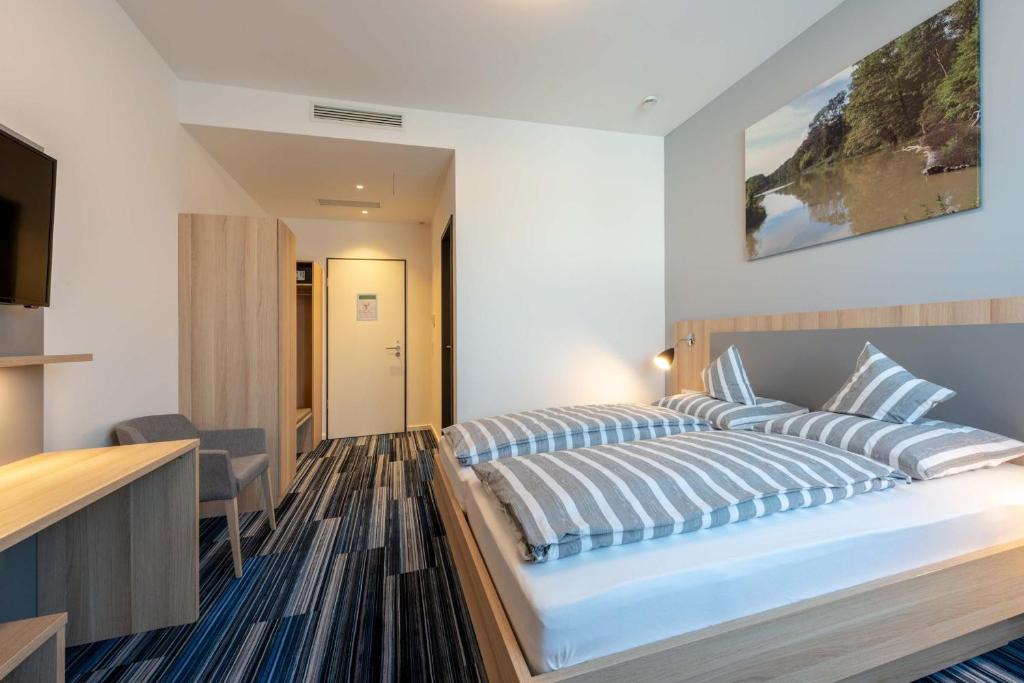 1 dormitorio con 1 cama grande con almohadas azules y blancas en Hotel Lumi, en Freiburg im Breisgau