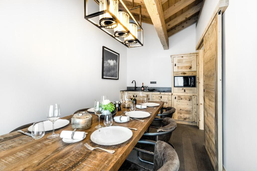 a dining room with a large wooden table and chairs at Hôtel La Sivolière in Courchevel