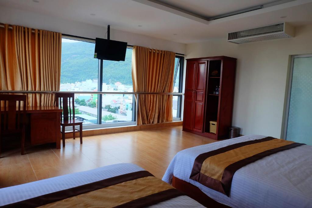 Green Hotel Quy Nhơn tesisinde bir odada yatak veya yataklar