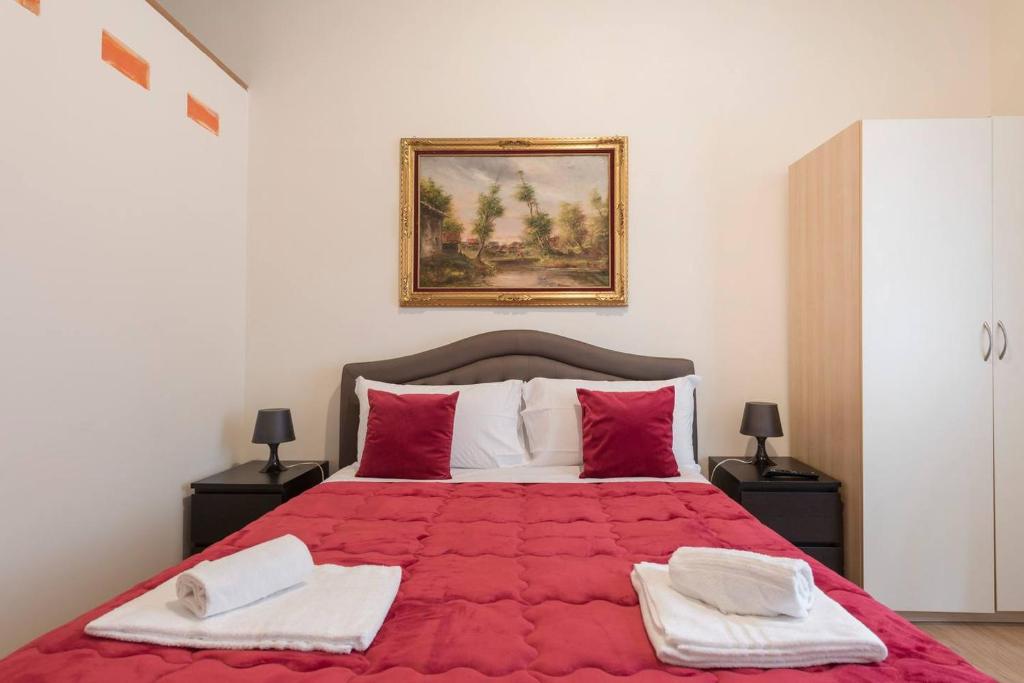 een slaapkamer met een rood bed en 2 handdoeken bij Via Umberto in Rome