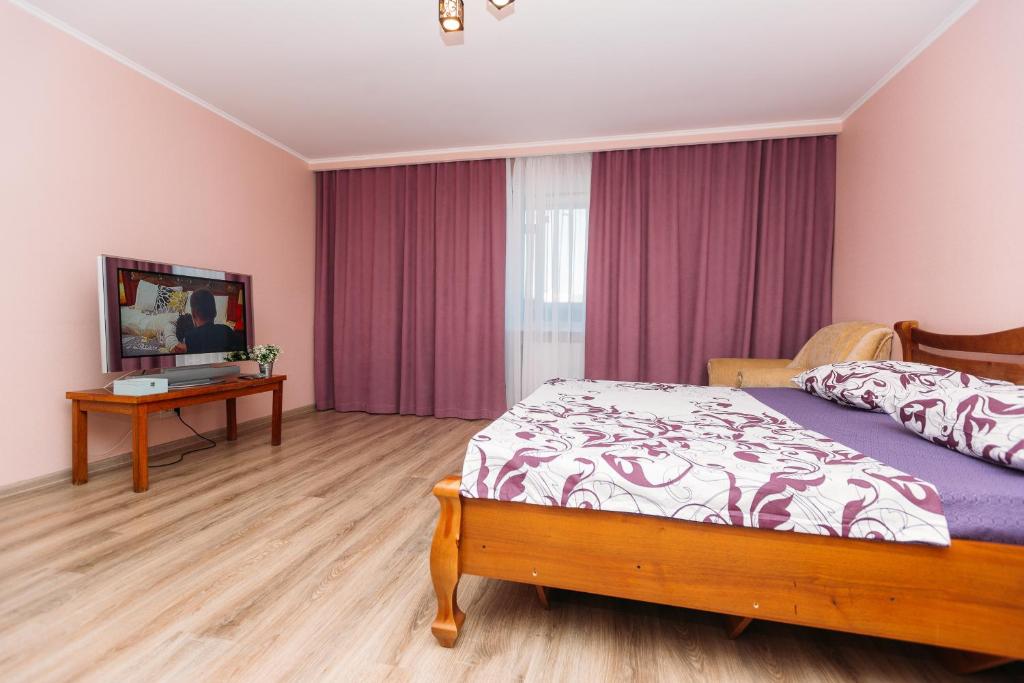 een slaapkamer met een bed en een tafel. bij VIP Apartments Faraon on Kharkovskaya 5 floor in Sumy
