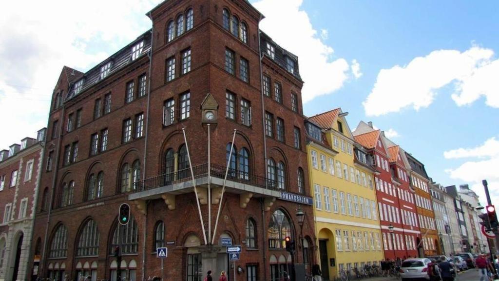 a large brick building with a balcony on a street at Hotel Bethel in Copenhagen