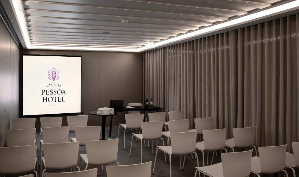 A conference room is arranged in rows facing a branded projection screen.