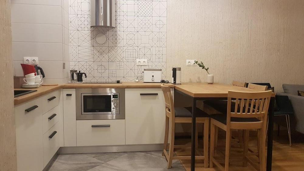 a small kitchen with a table and a microwave at LVIV WALL STREET APT in Lviv