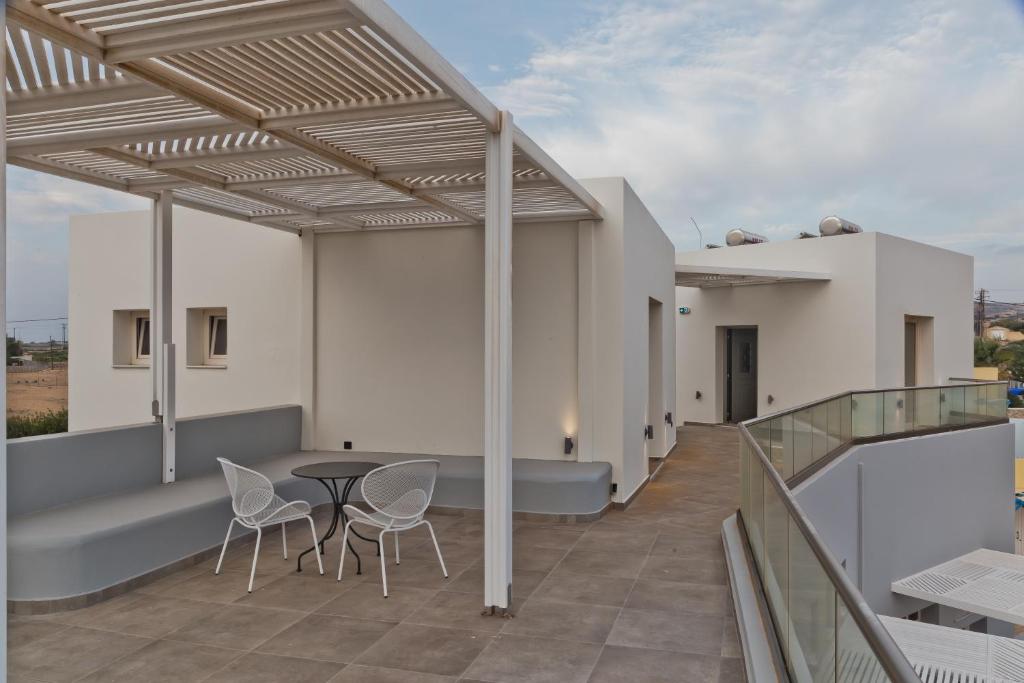 a balcony of a house with a table and chairs at Kalimera Karpathos Exclusive Villas in Afiartis