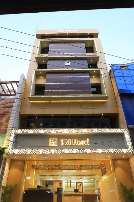 a tall building with a sign that reads im hotel at TM Hotel in Madurai