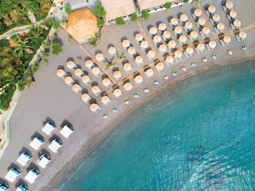 an aerial view of a resort with chairs and water at Out Of The Blue Resort & Spa in Agia Pelagia