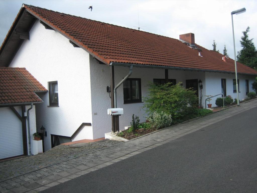 a white house with a red roof on a street at Kelten-Ferienwohnung in Glauburg