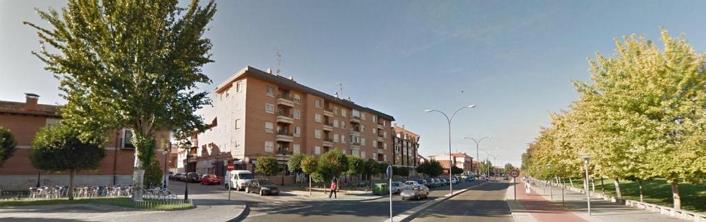 a city street with a building and cars on the road at LA LAGUNA in Laguna de Duero