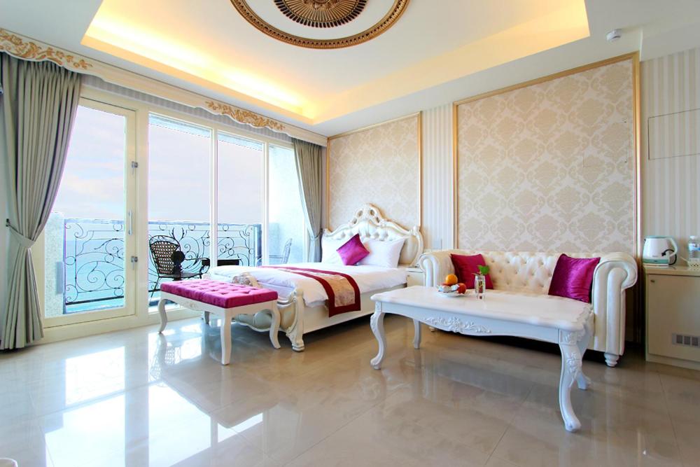 a bedroom with a bed and a couch and a window at Starrise Leisure Hotel in Dahan