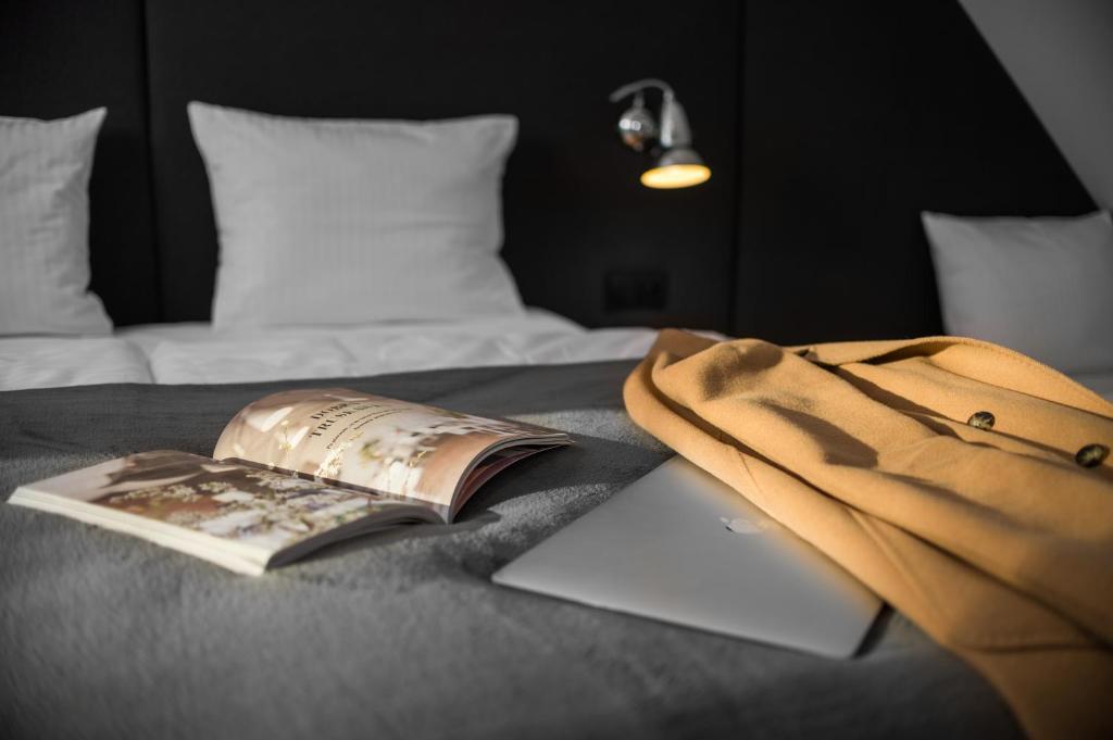 ein Buch und eine Tasche auf einem Bett mit einem Laptop in der Unterkunft dobra truskawka in Wągrowiec