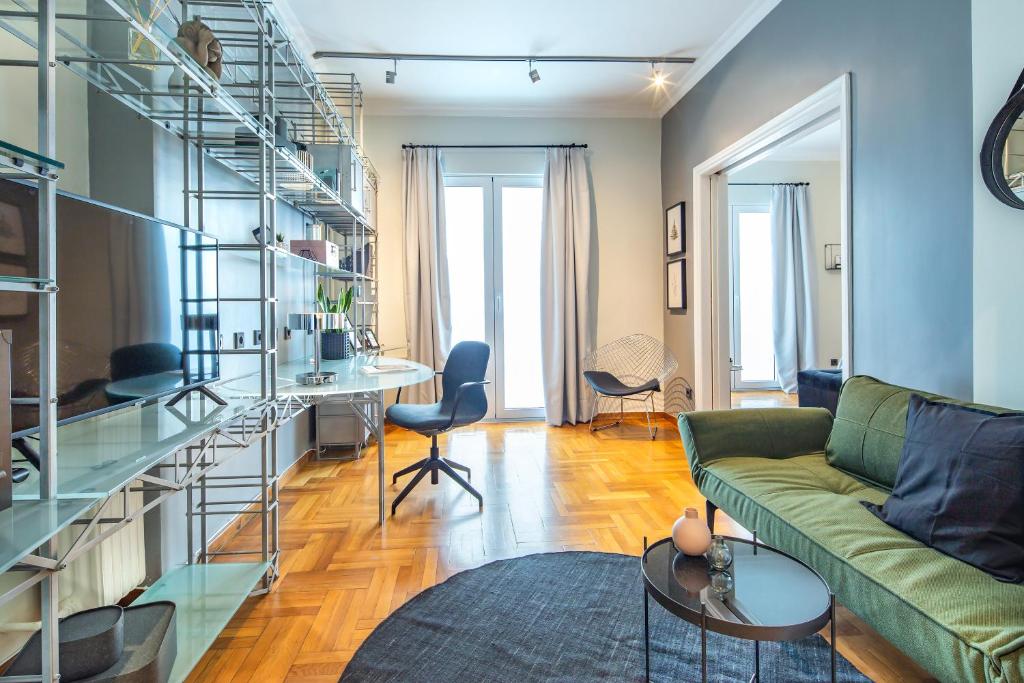 アテネにあるSuperb 1BD Apartment in the heart of Kolonaki by UPSTREETのリビングルーム(緑のソファ、ガラスの棚付)