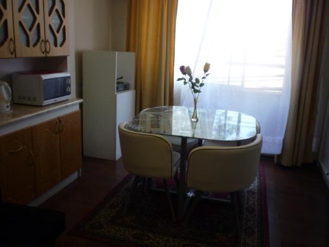 a table with a vase of flowers on top of it at Rodeo Departamentos Amoblados in Rancagua