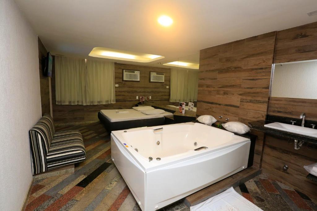 een badkamer met een bad, een wastafel en een bed bij Eden Hotel (Adults Only) in Rio de Janeiro