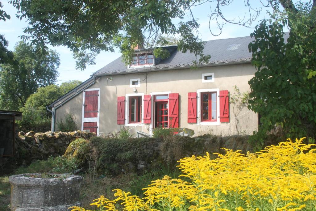 uma casa com janelas vermelhas e uma parede de pedra em Gîte de Rangère em Villapourçon