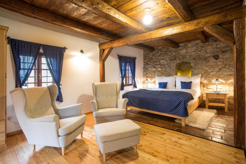 a bedroom with a king sized bed and two chairs at ANTIK in Štramberk