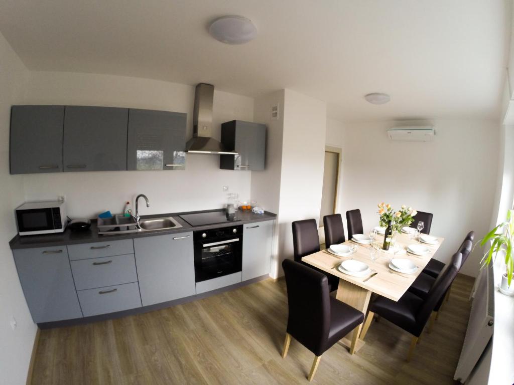 cocina y comedor con mesa y sillas en Apartments Andrej, en Ptuj