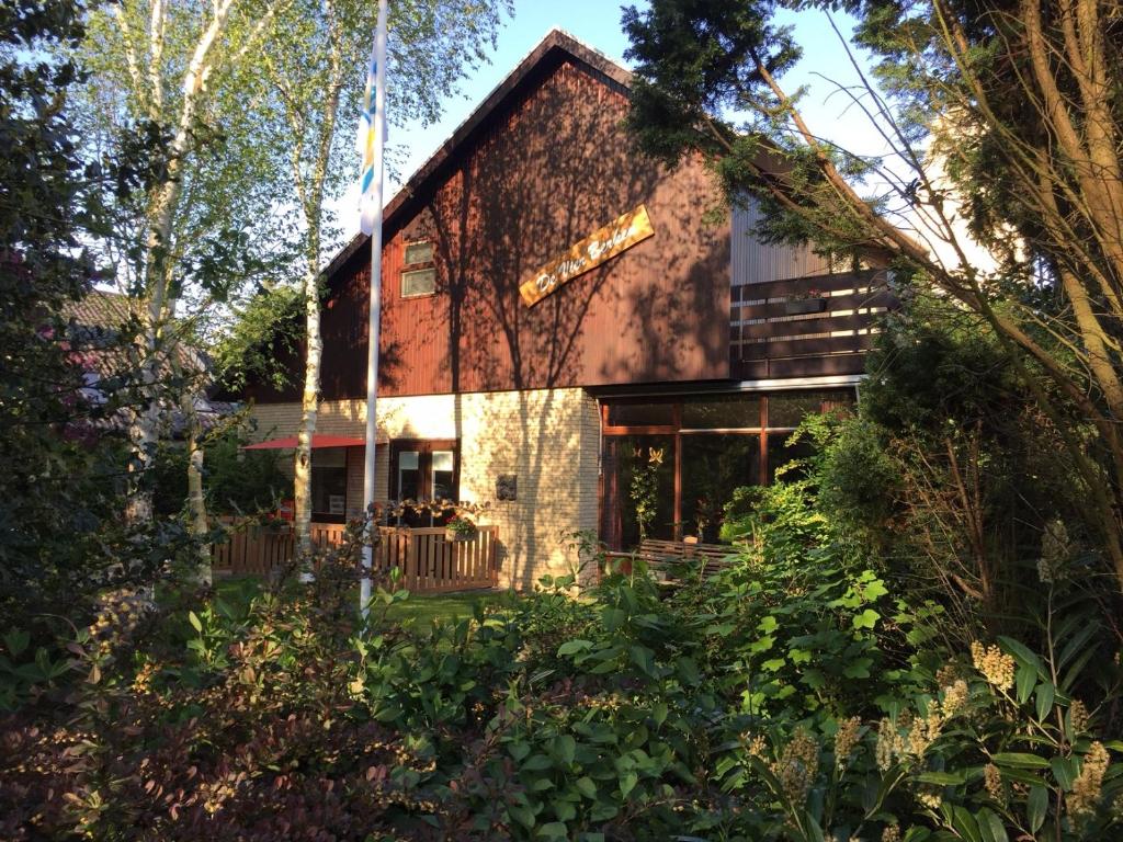 una casa con un jardín delante de ella en De vier Berken 1, en De Koog