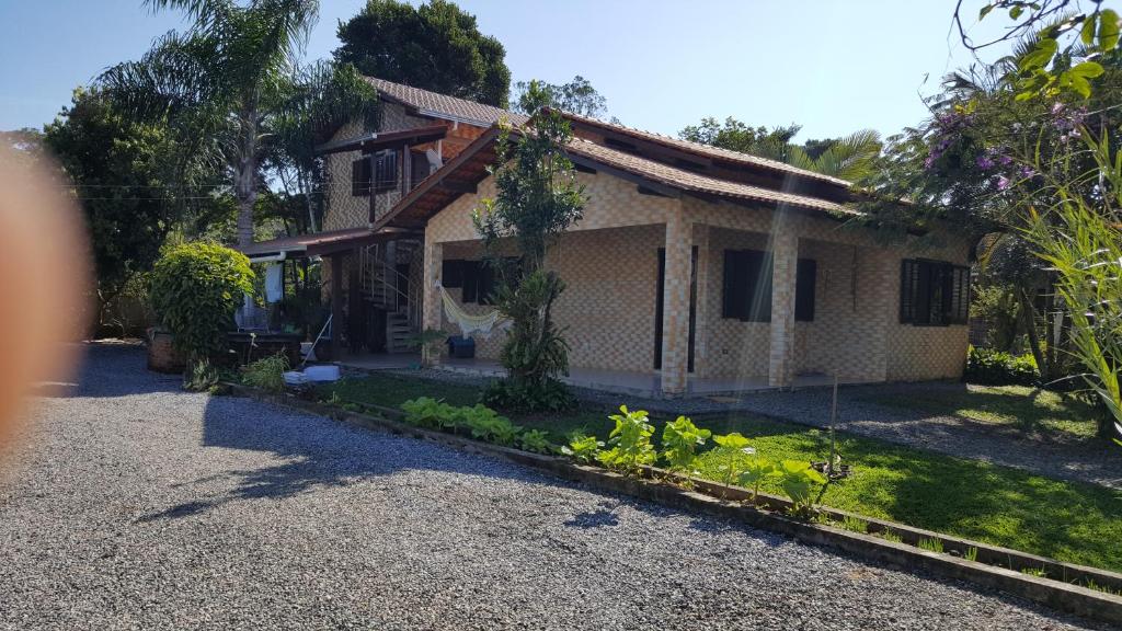 uma casa com um jardim em frente em Quarto Suíte Itapoá - SC em Itapoá