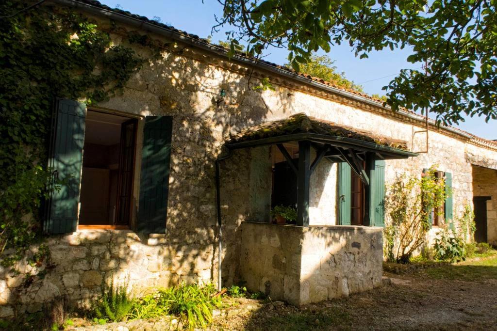 une ancienne maison en pierre avec une porte ouverte dans l'établissement La Ferme du Chateau, à Laplume