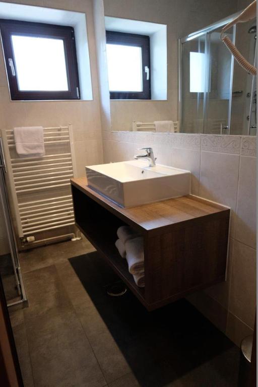 a bathroom with a sink and a mirror at Hotel Flores in Poreč