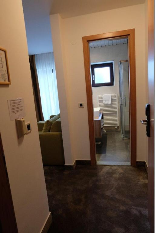 a hallway leading to a living room with a couch at Hotel Flores in Poreč