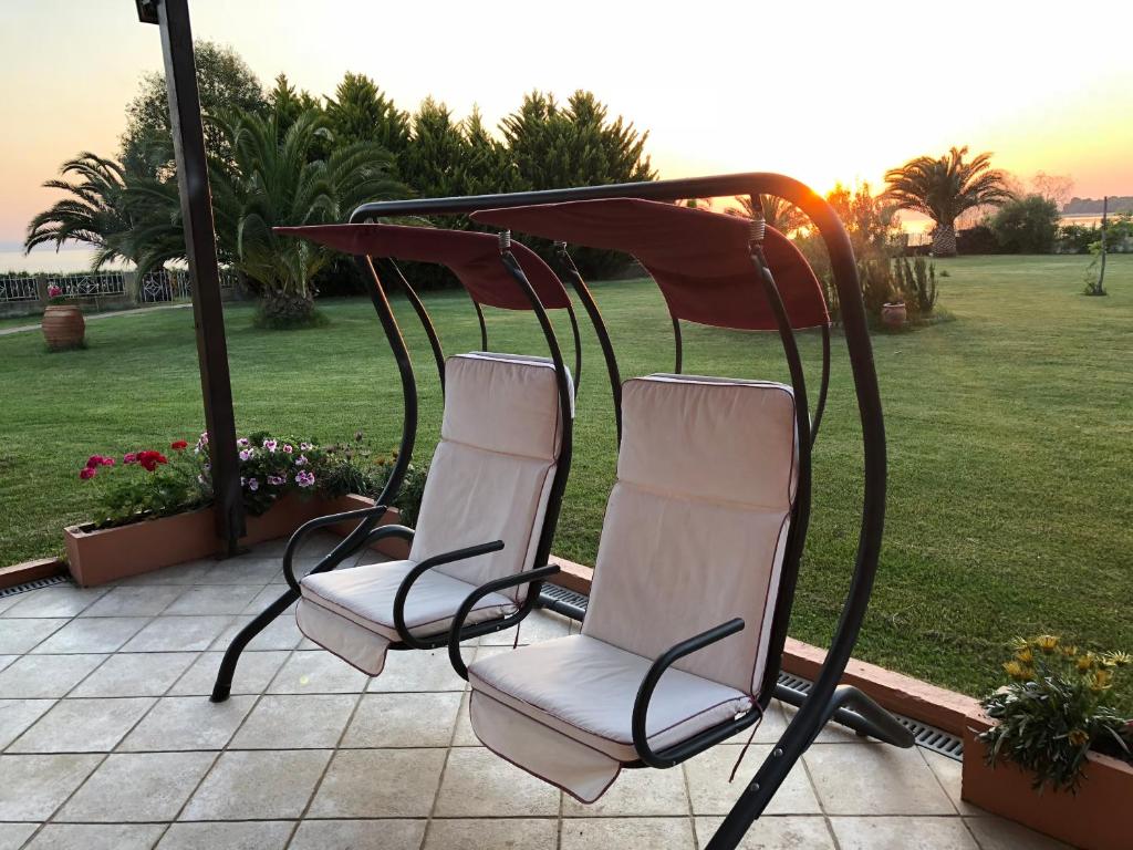 2 sedie sedute sotto un tavolo su un patio di DISTRiCT 01 -Luxurious Villa with private beach a Metókhion Konstamonítou