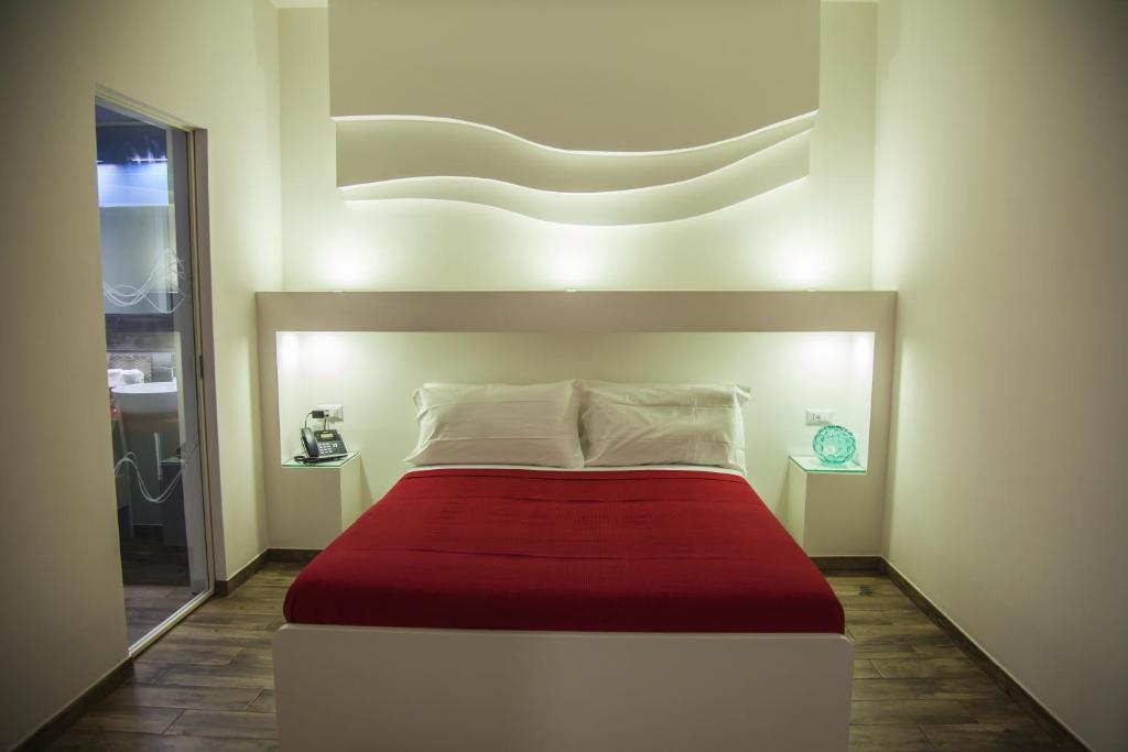 1 dormitorio con 1 cama grande con manta roja en VILLA ADELAIDE SUITE & ROOM, en Torre a Mare