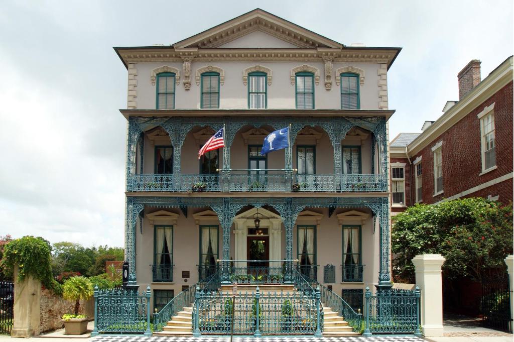 Una vieja casa con dos banderas americanas. en John Rutledge House Inn, en Charleston
