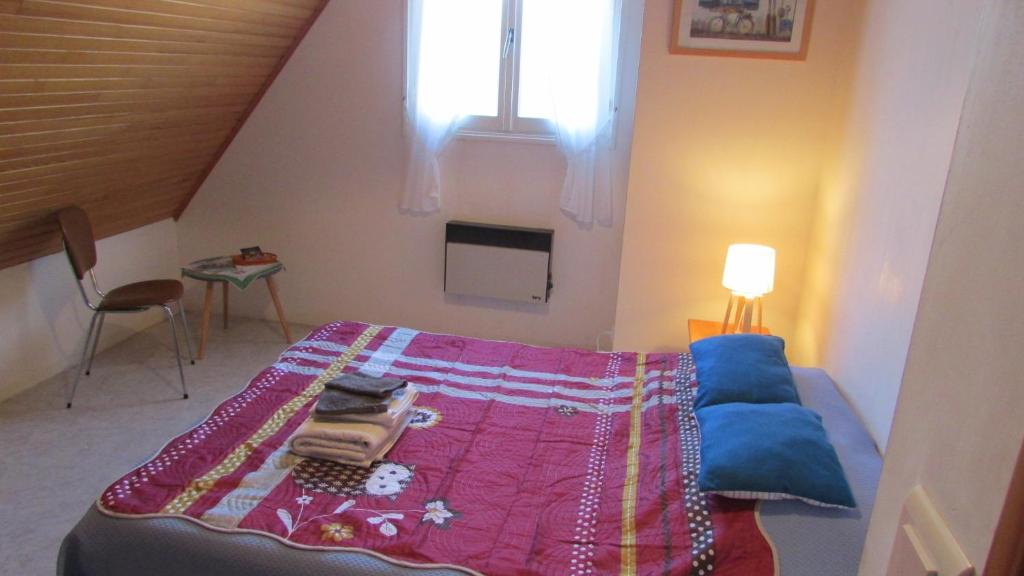sypialnia z łóżkiem z fioletowym kocem w obiekcie la vallee w mieście Plogoff