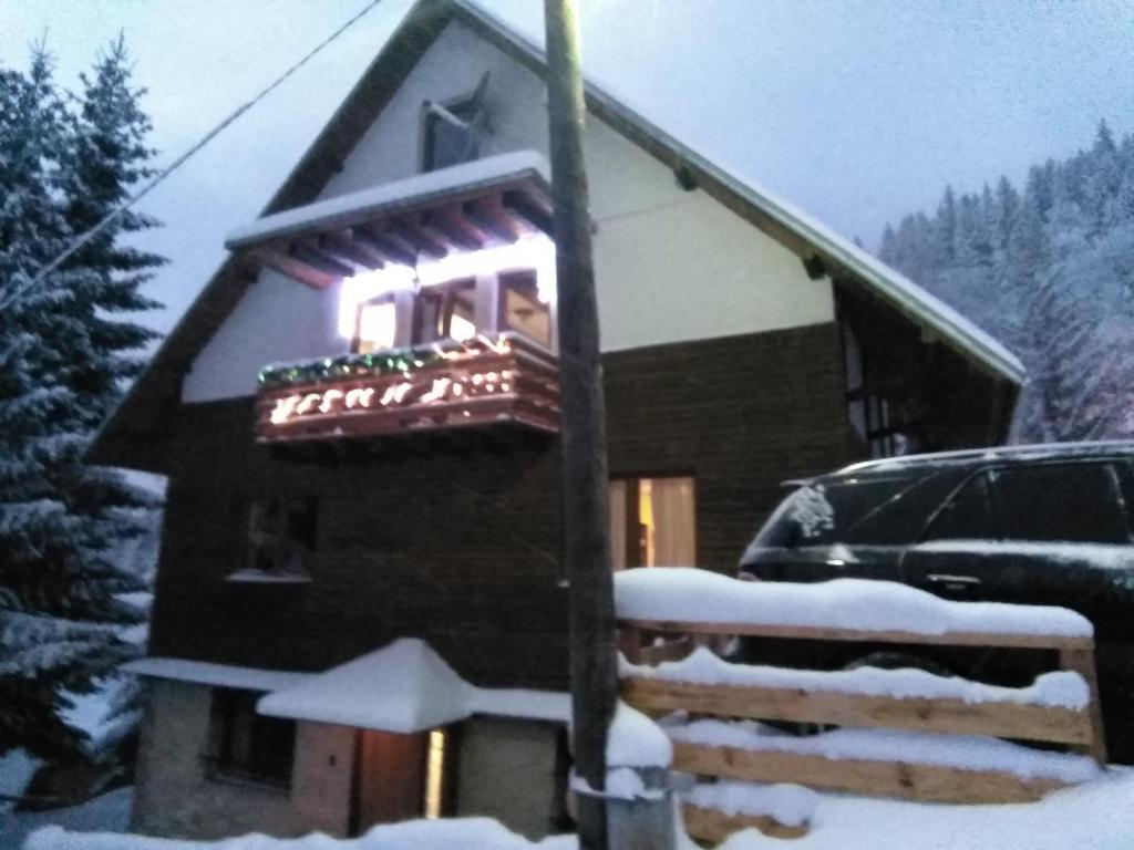 a building with a sign on it in the snow at Apartman Vila Natasa in Kopaonik