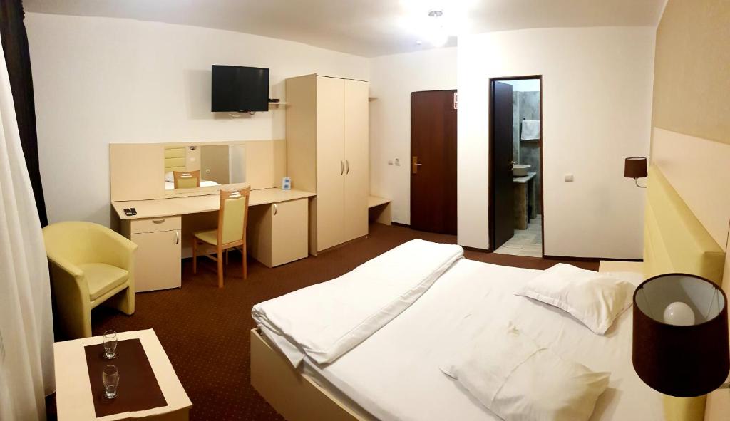 a hotel room with a bed and a desk and a computer at MBI Travel Inn in Craiova