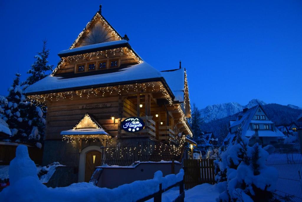 un edificio con una torre del reloj con luces de Navidad en Willa Hiacynta, en Zakopane