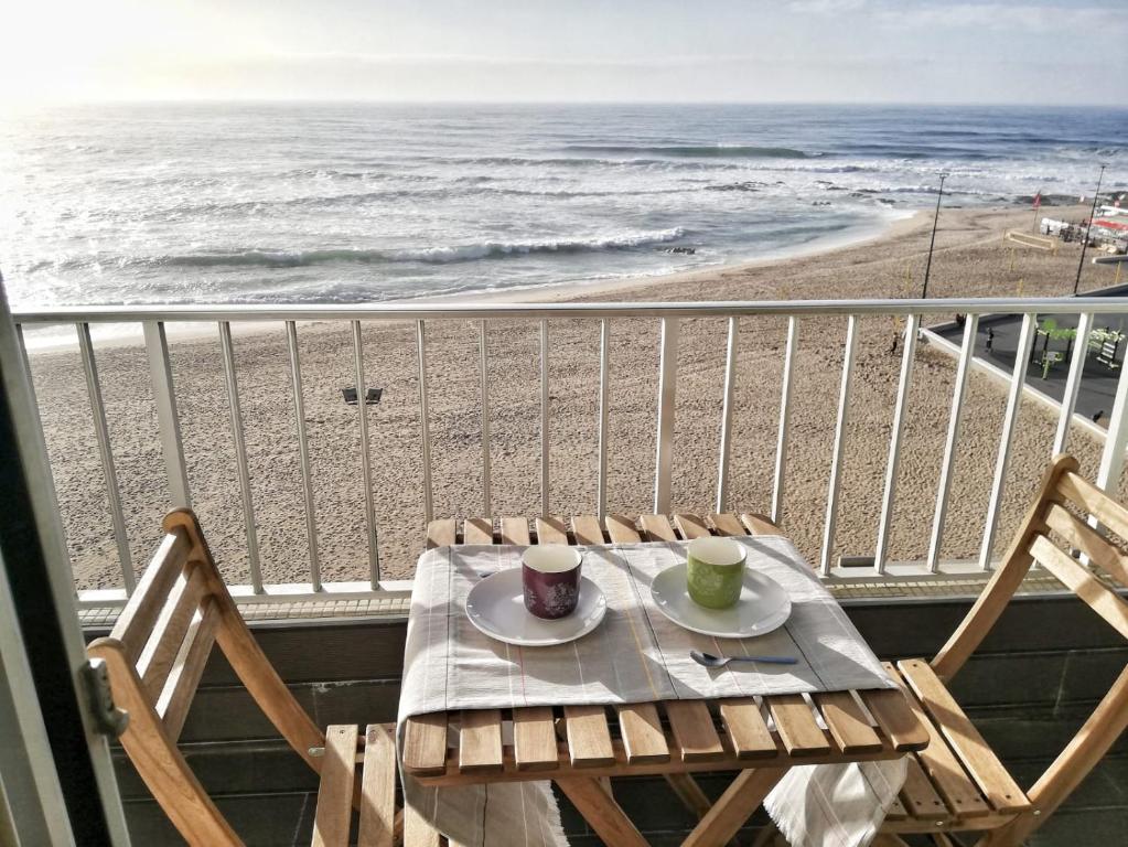 a table and chairs on a balcony with the beach at Mar Beach Apartment in Póvoa de Varzim