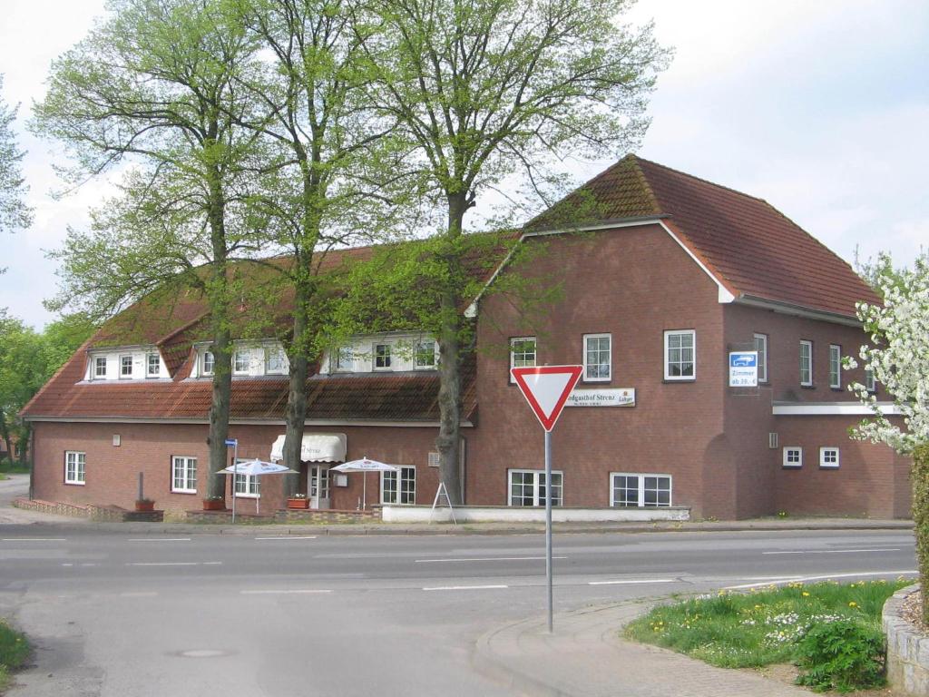 un gran edificio de ladrillo con una señal de rendimiento delante de él en Landpension Strenz, en Lüssow