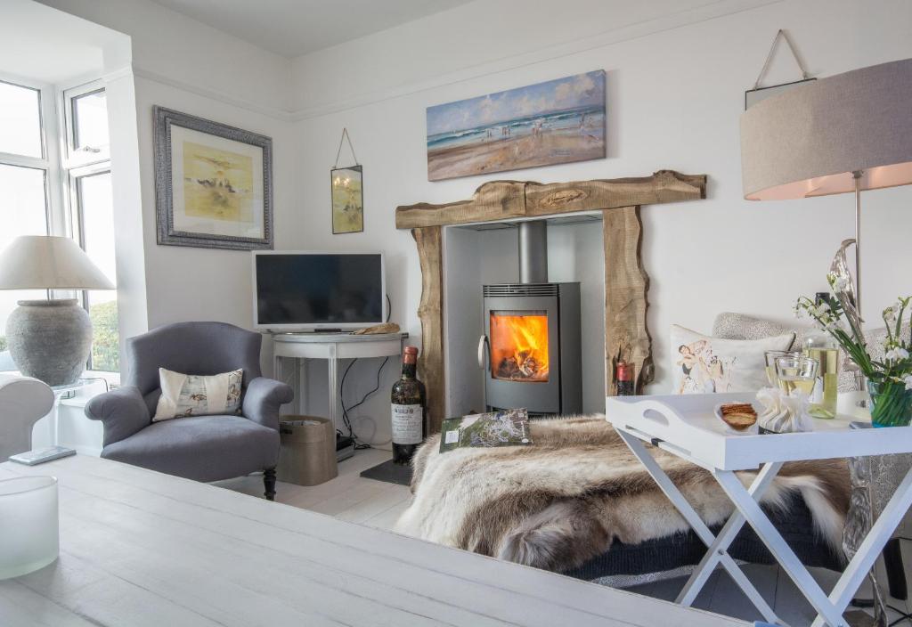 a living room with a fireplace and a couch at Creagle, Sennen Cove in Sennen Cove