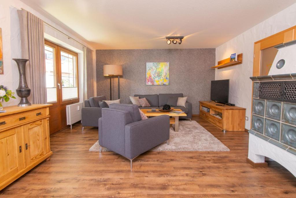 uma sala de estar com um sofá e uma televisão em Sonnenreite em Fischen