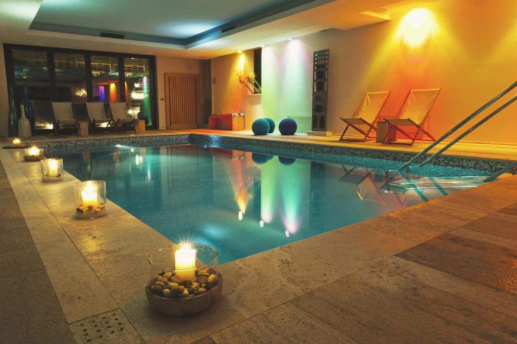 a swimming pool with candles and lights in a house at Roccafiore Spa & Resort in Todi