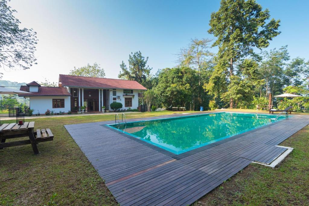 a swimming pool in the yard of a house at Estancia Holiday Bungalow in Matale