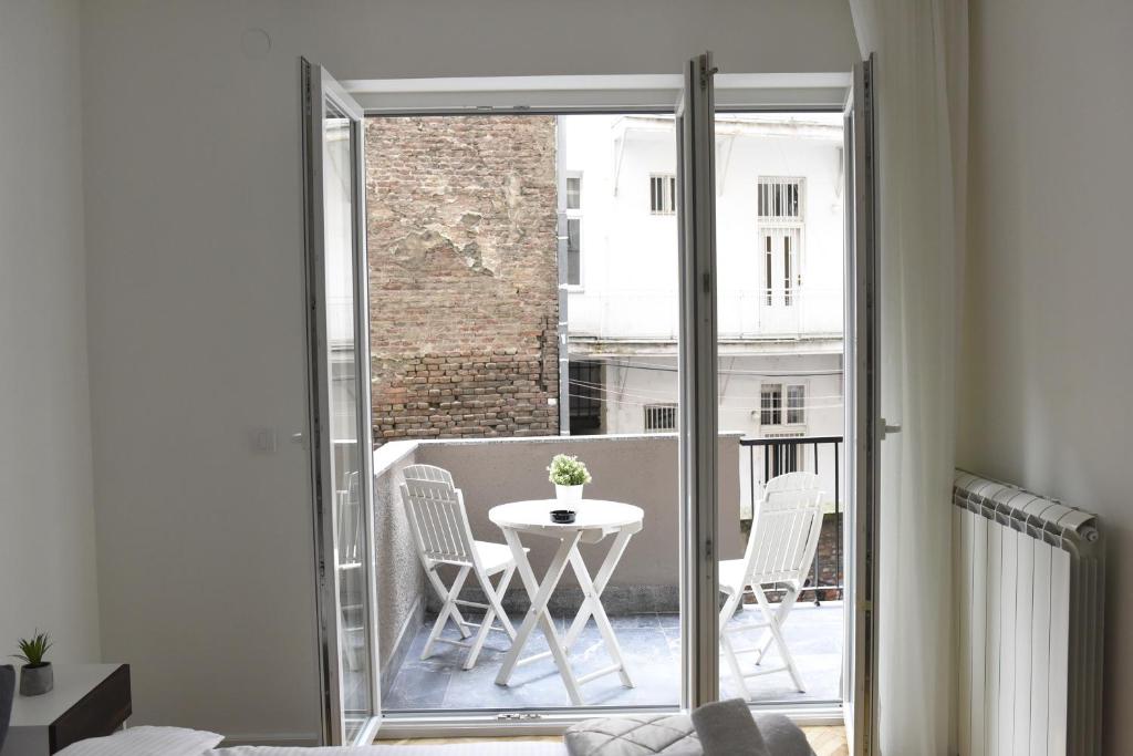a room with a balcony with a table and chairs at Apartments Belvedere in Belgrade