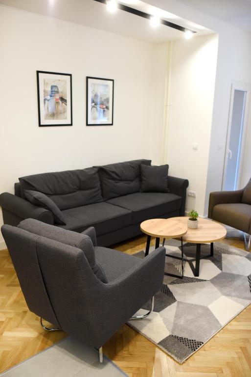 a living room with a black couch and a table at Apartments Belvedere in Belgrade